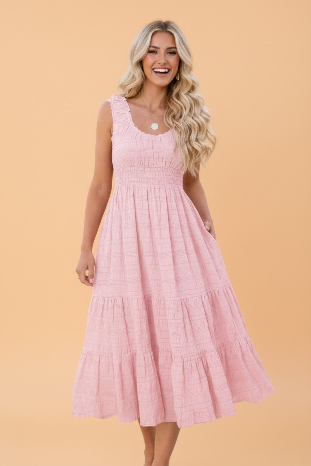 Woman wearing a pink dress against a beige background