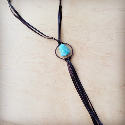 Necklace with a turquoise stone on a light wooden surface