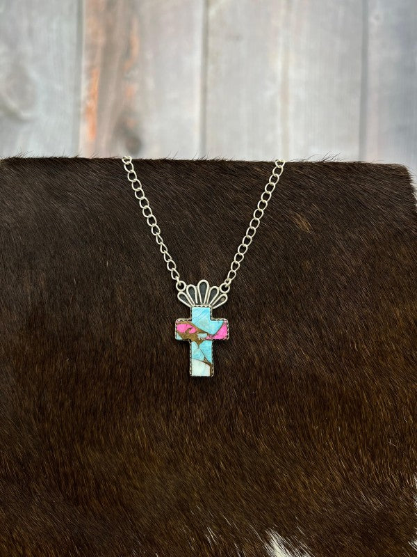 Necklace with a cross pendant on a brown  fur surface