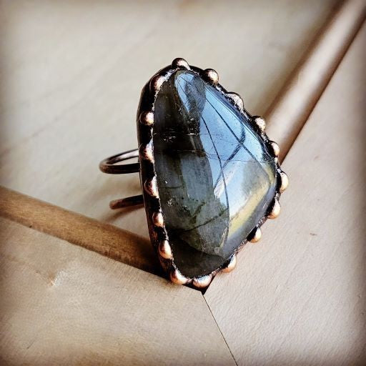 Ring with a large, faceted gemstone on a textured surface